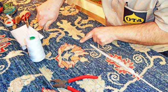 Unserer Knüpfer näht ein Teppich, der gekürzt wurde, zusammen Zusammennähen eines verkürzten Orientteppichs