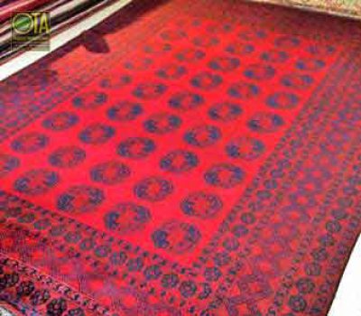 Ein Afghan Teppich wird in der Mitte durchgeschnitten und verkürzt Alter Teppich vor Verkürzen